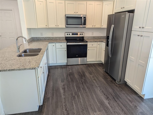 kitchen featuring stainless steel appliances, light stone counters, sink, dark hardwood / wood-style floors, and white cabinets