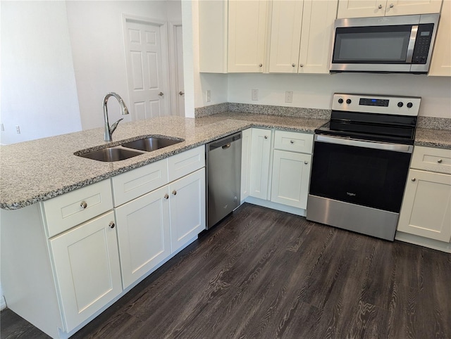 kitchen featuring stainless steel appliances, sink, kitchen peninsula, and white cabinets