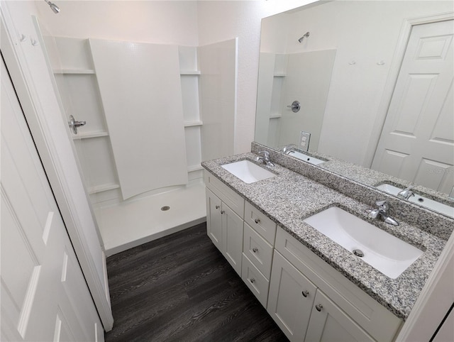 bathroom featuring a shower, wood-type flooring, and vanity