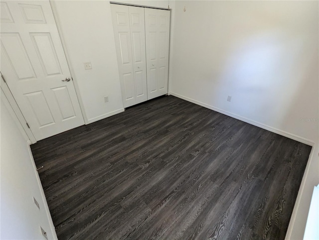 unfurnished bedroom with a closet and dark hardwood / wood-style floors