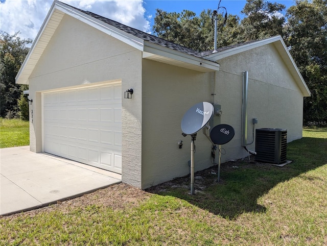 view of side of home featuring central air condition unit, a garage, and a yard