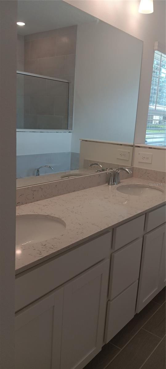 bathroom with vanity, tile patterned floors, and a tile shower