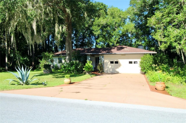 view of front of property with a garage, a chimney, a front lawn, and concrete driveway