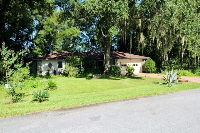 ranch-style home featuring a garage and a front yard