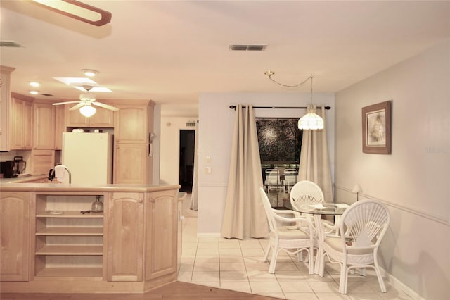 dining room featuring a ceiling fan, visible vents, and light tile patterned flooring