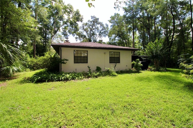 view of side of property featuring a yard and stucco siding