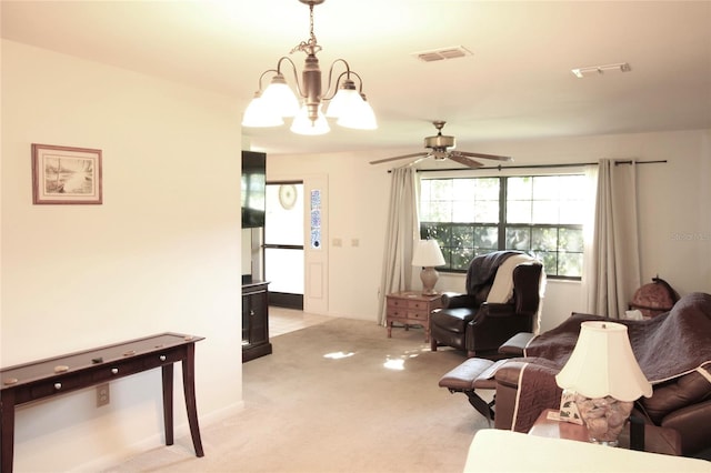 carpeted living room with ceiling fan with notable chandelier