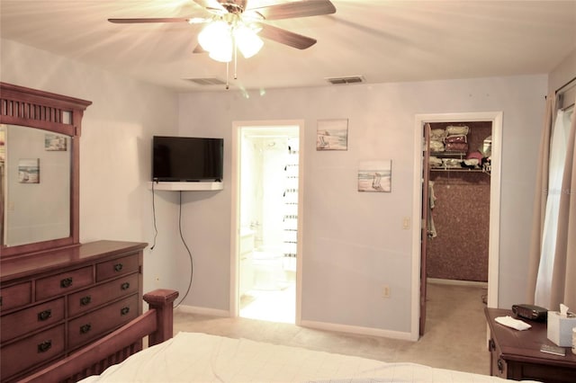 bedroom featuring connected bathroom, ceiling fan, a closet, a spacious closet, and light colored carpet