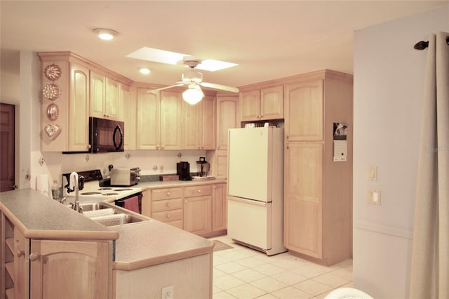 kitchen with white appliances, a skylight, light brown cabinetry, kitchen peninsula, and ceiling fan