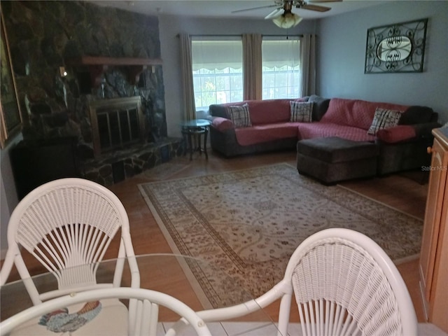 living room with ceiling fan, a high end fireplace, and hardwood / wood-style floors