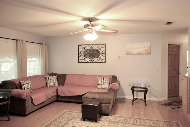 living room with ceiling fan and light hardwood / wood-style flooring