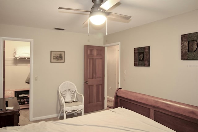 carpeted bedroom with ceiling fan, a walk in closet, and a closet