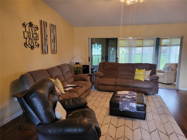 living room with hardwood / wood-style flooring, lofted ceiling, a textured ceiling, and french doors