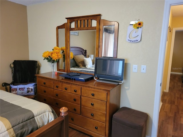 bedroom with dark hardwood / wood-style flooring