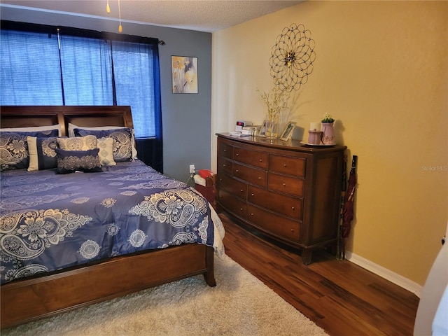 bedroom featuring hardwood / wood-style floors and a textured ceiling