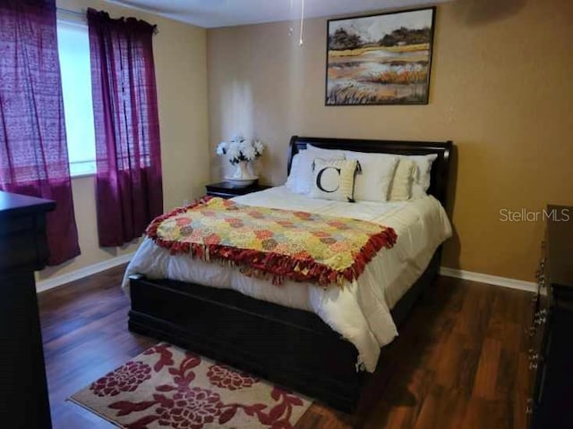 bedroom with dark hardwood / wood-style floors