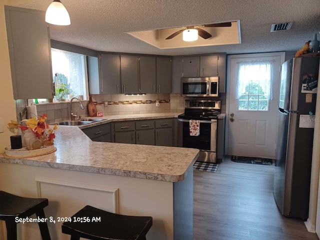 kitchen with a kitchen breakfast bar, sink, kitchen peninsula, and stainless steel appliances