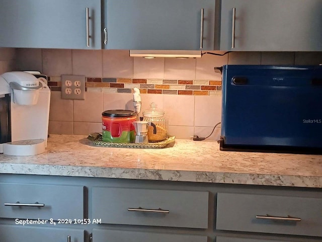 interior details featuring tasteful backsplash and gray cabinets