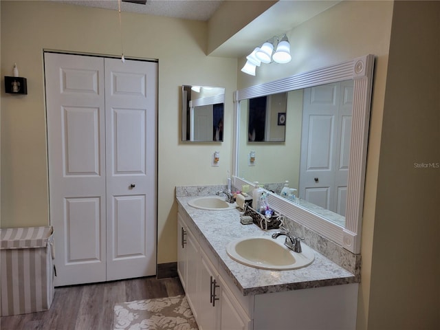 bathroom with hardwood / wood-style floors, vanity, and a textured ceiling