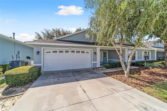 ranch-style house with a garage and central AC unit