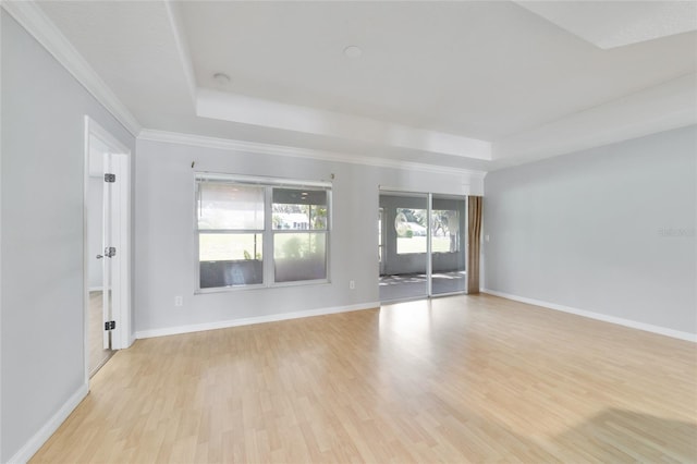 interior space featuring crown molding, a raised ceiling, and light hardwood / wood-style floors