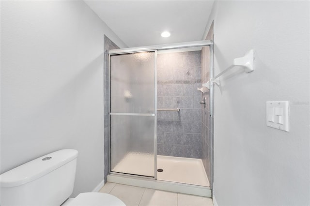 bathroom with toilet, a shower with shower door, and tile patterned floors