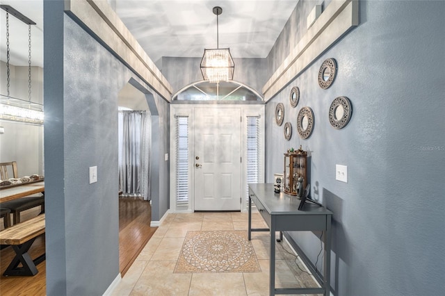 entryway featuring light wood-type flooring and a notable chandelier