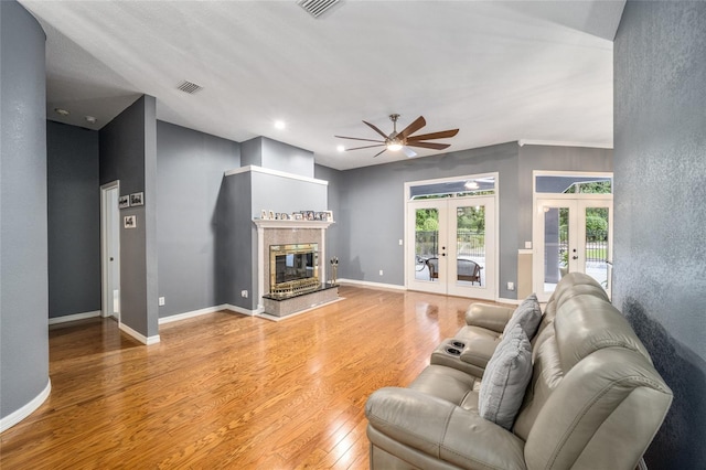 living room featuring hardwood / wood-style floors, ceiling fan, and french doors