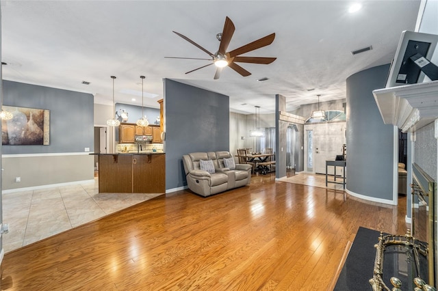 living room featuring light hardwood / wood-style flooring and ceiling fan