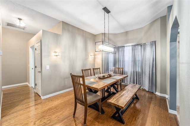 dining room with vaulted ceiling and light hardwood / wood-style flooring