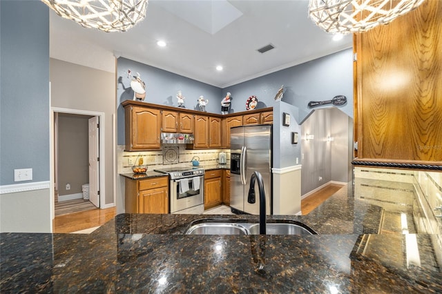 kitchen featuring pendant lighting, stainless steel appliances, an inviting chandelier, and sink