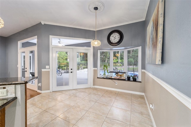 unfurnished dining area with crown molding, light tile patterned floors, and french doors