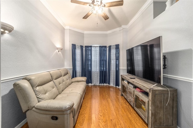 living room with crown molding, light hardwood / wood-style flooring, and ceiling fan