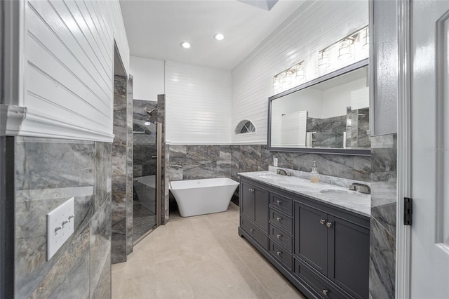 bathroom with tile patterned floors, vanity, tile walls, and shower with separate bathtub