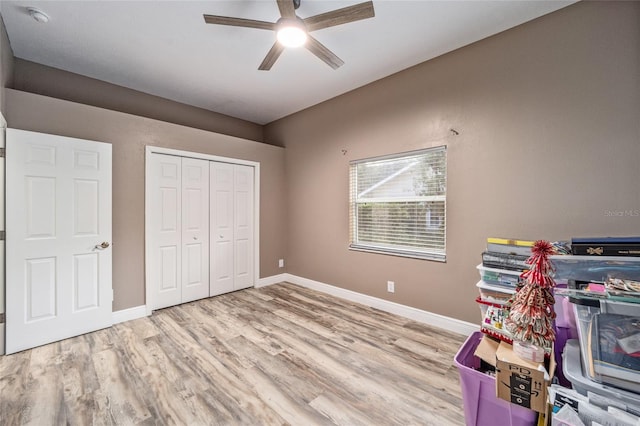 unfurnished bedroom with ceiling fan, a closet, and light wood-type flooring