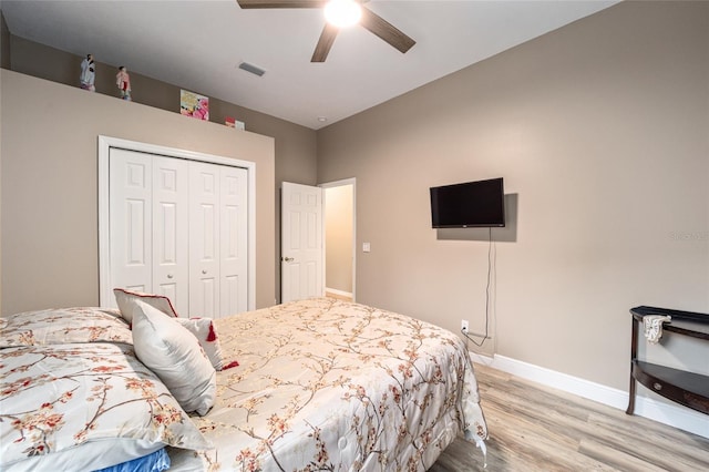 bedroom with light hardwood / wood-style flooring, ceiling fan, and a closet