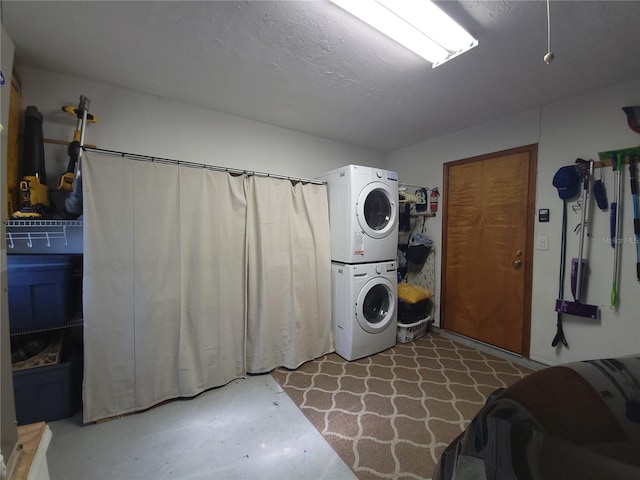 clothes washing area with a textured ceiling and stacked washer and dryer