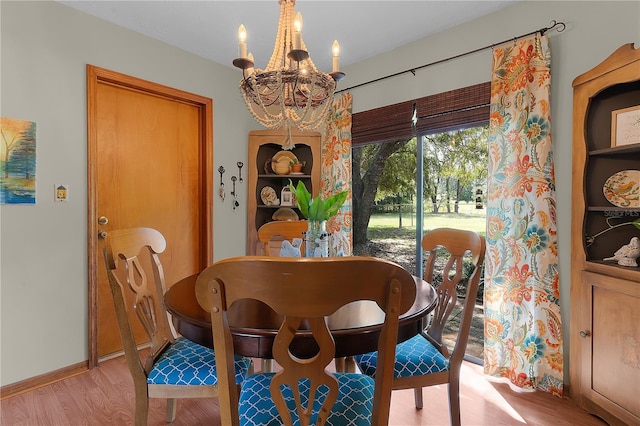 dining room with light hardwood / wood-style floors and a notable chandelier