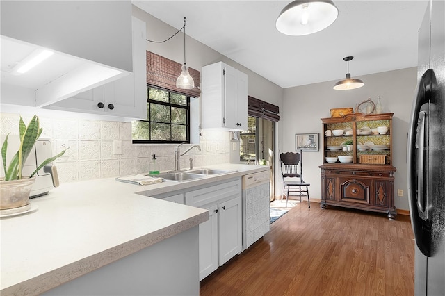 kitchen featuring white dishwasher, white cabinetry, hanging light fixtures, and sink