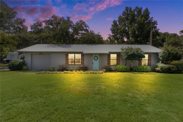 single story home with a lawn and a garage