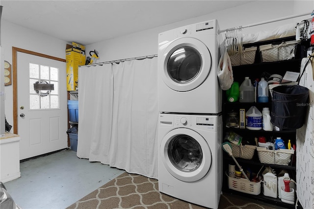 clothes washing area with stacked washing maching and dryer