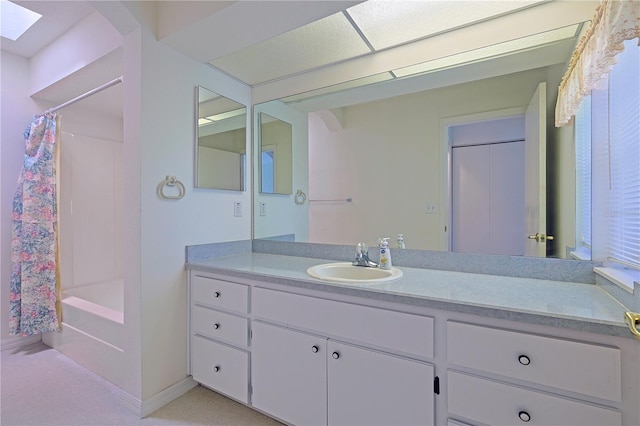 bathroom featuring vanity, shower / bathtub combination with curtain, and a skylight