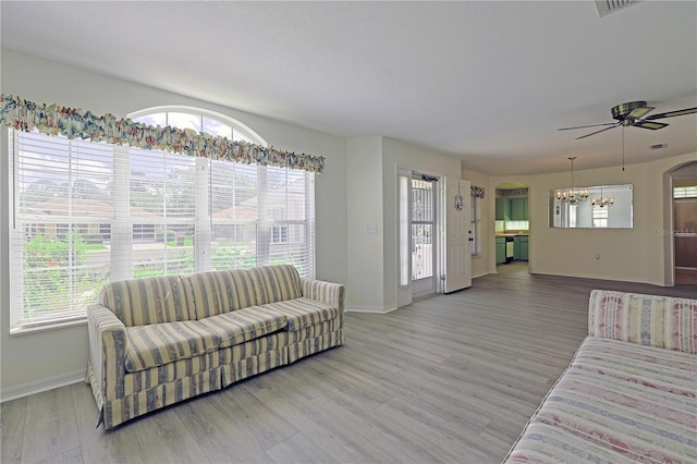 living room featuring light hardwood / wood-style flooring, ceiling fan, and a wealth of natural light