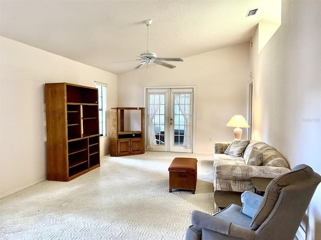 living room featuring carpet floors, a textured ceiling, lofted ceiling, ceiling fan, and french doors