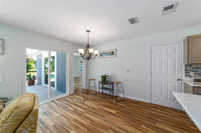 dining room featuring light wood-style floors, a chandelier, and baseboards
