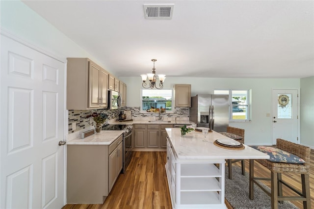 kitchen featuring appliances with stainless steel finishes, open shelves, a chandelier, light countertops, and tasteful backsplash