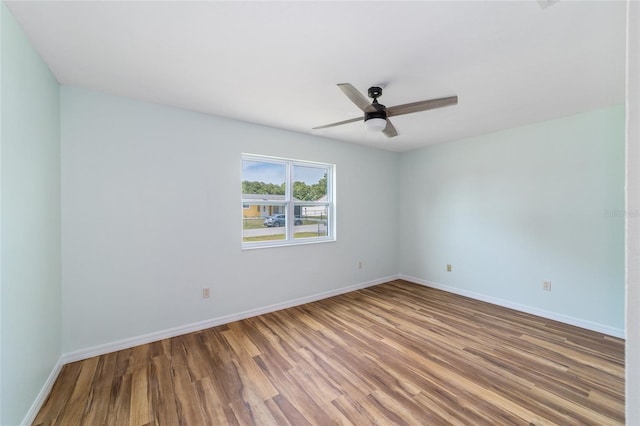 unfurnished room featuring wood finished floors, ceiling fan, and baseboards