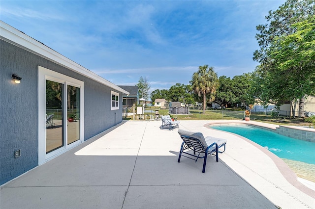 view of swimming pool with a patio area and fence