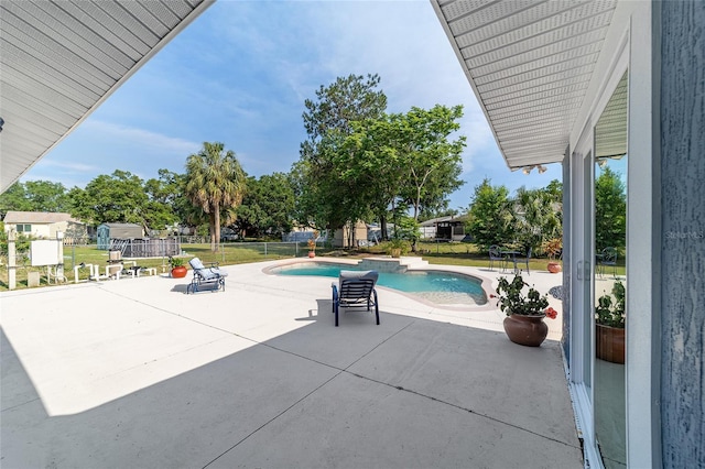 view of pool with a patio, fence, and a jacuzzi