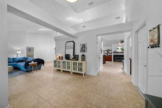 corridor featuring light tile patterned floors and lofted ceiling